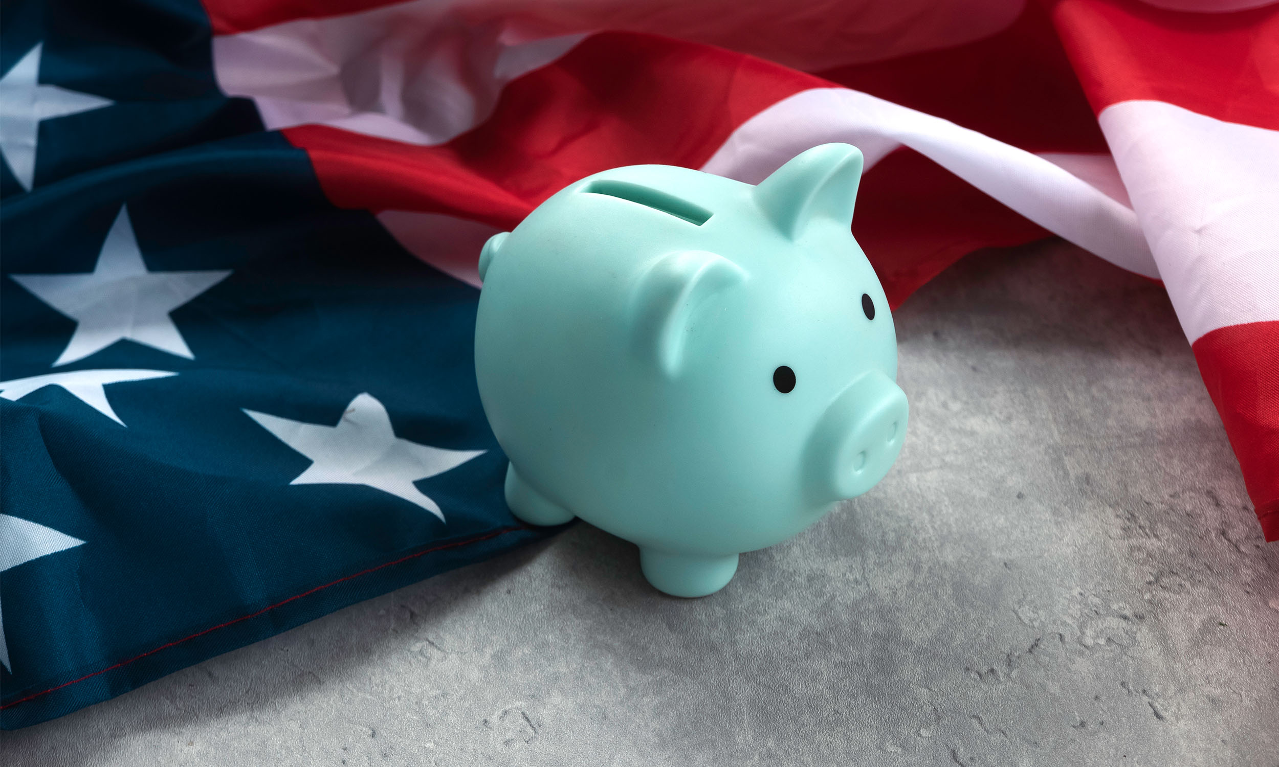 A piggy bank with an American flag behind it. The Big Beautiful Bill concept.